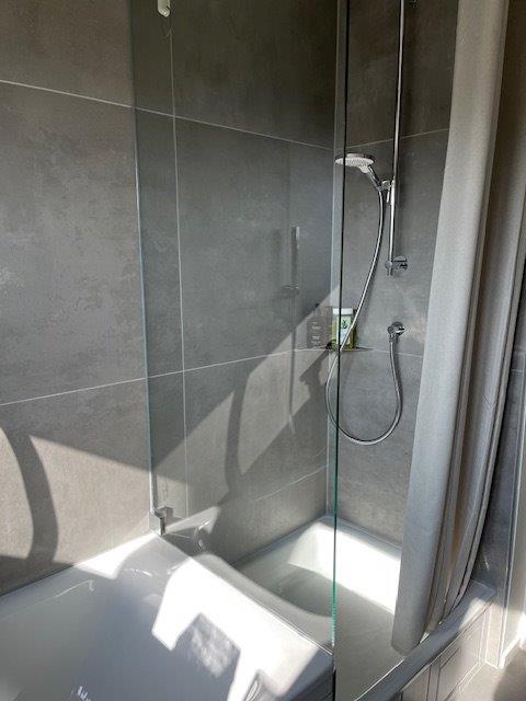 Referenzbild Bad in Grautönen Dusche Glasabtrennung zwischen Badewanne und Dusche