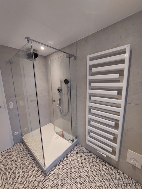 Referenzbild Bad mit hellgrauen Fliesen Bodenfliesen gemustert Duschkabine Badheizkörper in weiß